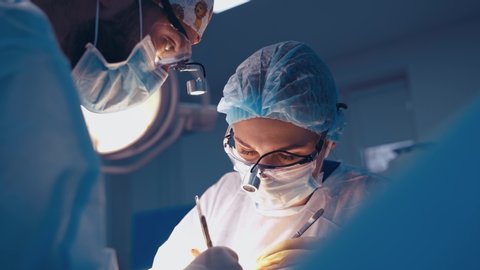 Doctor during surgery in operating room. Professional doctor performing operation in surgery room
