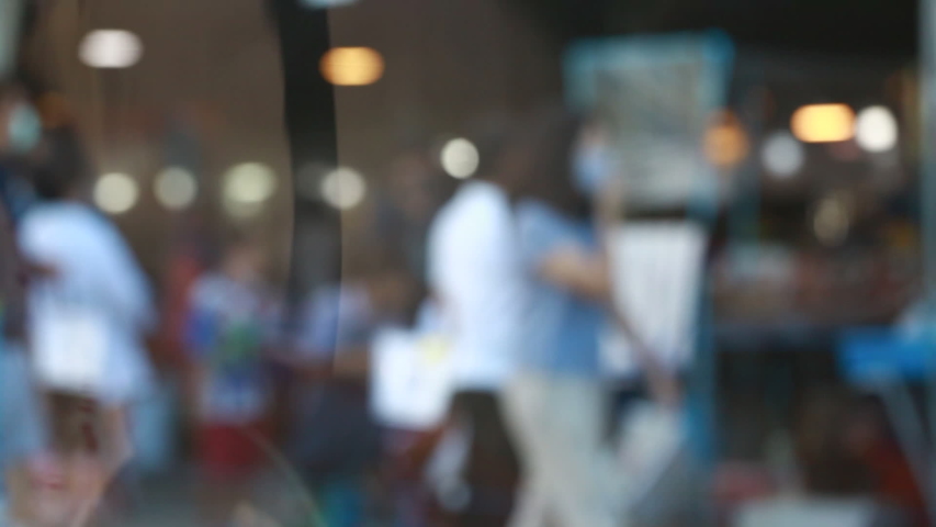 Blurry many people wearing mask and walking to shopping in the fresh market at Bangkok, Thailand. Slow motion video.