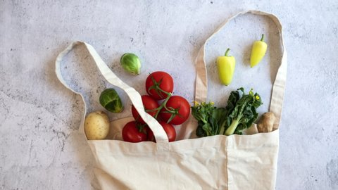 grocery vegan product gathering on the reusable bag on flat lay design. fresh vegetable shopping  .stop motion video