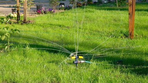 lawn irrigation system, lawn sprinkler for watering grass in operation, sprays water in a circle.