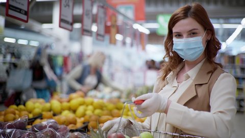 shopping coronavirus, a cheerful buyer in a medical mask chooses useful products to maintain health during a pandemic due to coronavurus