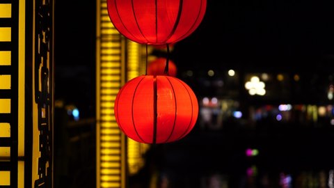 Decorative chinese red lanterns hangs on a wall on the street at night in Hoi An old town, Vietnam, close up