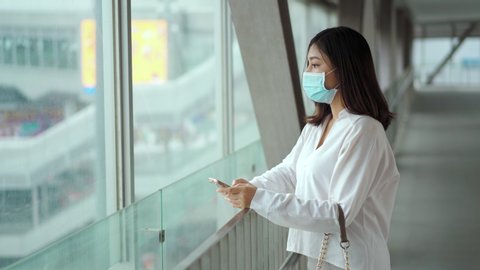 young asian woman wearing medical mask for prevention from coronavirus (Covid-19) pandemic in the city. new normal concepts