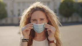 Put on your respirator to protect the other people. Pandemic coronavirus covid concept. Curly blond woman putting on surgical protective mask for corona virus second outbreak prevention. 6K Downscale - Powered by Shutterstock - Get 15% off with code: PIKWIZARD15