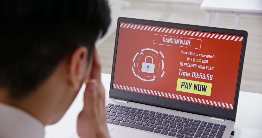 Back view of asian worried young businessman looking at laptop computer with ransomware attack words on the screen in office | Shutterstock HD Video #1054728878