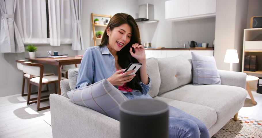 Smart AI speaker concept - asian young woman talk to voice assistant to control light turning off at home | Shutterstock HD Video #1054728983