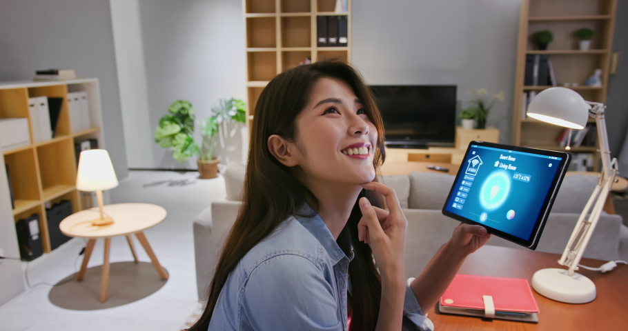 asian young woman using smart home app with voice assistant to control light turning on with tablet pc Royalty-Free Stock Footage #1054728998
