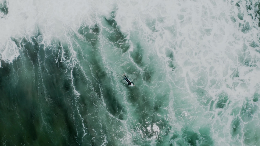 Brave and fearless cold water surfer athlete swim through big powerful waves, paddle to get to perfect surfing location point. Concept beauty and peace in sport in wild nature Royalty-Free Stock Footage #1054732409