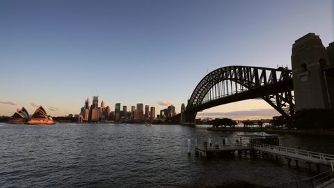 Water surface of Sydney Harbour across Circular Quay and major city landmark at sunset in fast motion time lapse.
