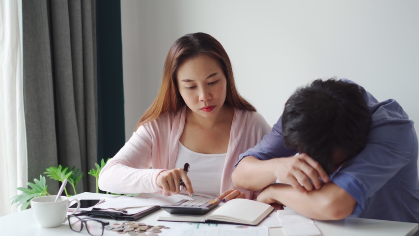 Stressed young couple calculating monthly home expenses, taxes, bank account balance and credit card bills payment, Income is not enough for expenses Royalty-Free Stock Footage #1054735052