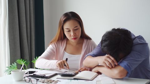 Stressed young couple calculating monthly home expenses, taxes, bank account balance and credit card bills payment, Income is not enough for expenses
