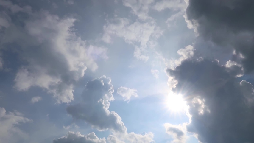 TimeLapse of beautiful sunny blue sky with bright sun light shining through white clouds & cumulus cloudscape in tropical summer or spring sunlight, sunbeam & sun ray flares at daylight sunshine day  Royalty-Free Stock Footage #1054735574