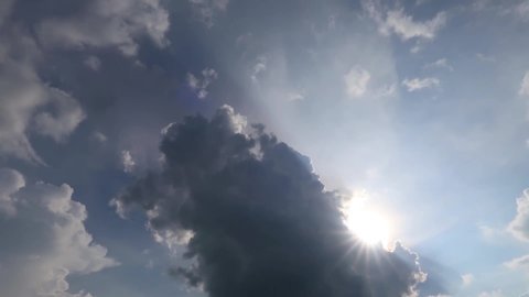 TimeLapse of beautiful sunny blue sky with bright sun light shining through white clouds & cumulus cloudscape in tropical summer or spring sunlight, sunbeam & sun ray flares at daylight sunshine day 