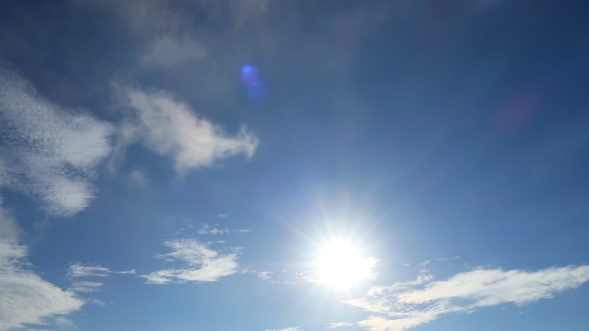 TimeLapse of beautiful sunny blue sky with bright sun light shining through white clouds  cumulus cloudscape in tropical summer or spring sunlight, sunbeam  sun ray flares at daylight sunshine day  | Shutterstock HD Video #1054735577