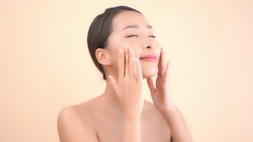 Close Up of Pretty Asian Woman Gently Rubbing Face With Anti Aging Balsam Cream, Skin Care Cosmetic and Beauty Concept
