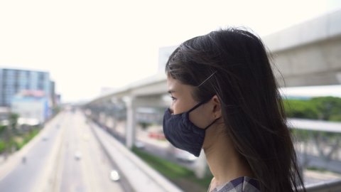 Portrait of Worried Young Asian Woman Wearing Face Mask in Urban Environment - New Normal After Covid-19