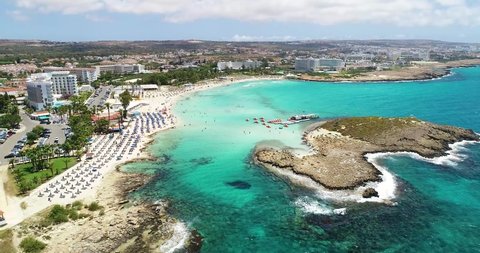 Aerial footage view of turquoise transparent crystal clean water of Nissi beach, Ayia Napa, Famagusta, Cyprus from above on a windy day.