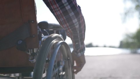 A man in a wheelchair walks on the waterfront