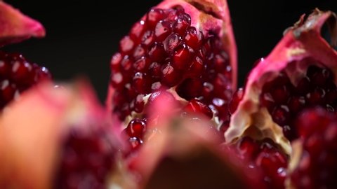 Pomegranate fruit. Fresh and ripe Pomegranates rotating over black Background. Organic Bio fruits close-up. Diet, dieting concept. Vegan food. Slow motion 4K UHD video. 