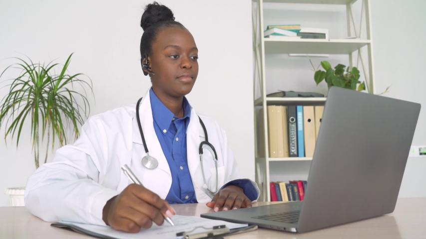 African female doctor talk with patient make telemedicine online webcam video call. Black woman therapist videoconferencing on computer in remote telemedicine laptop virtual chat. Telehealth concept Royalty-Free Stock Footage #1054741853