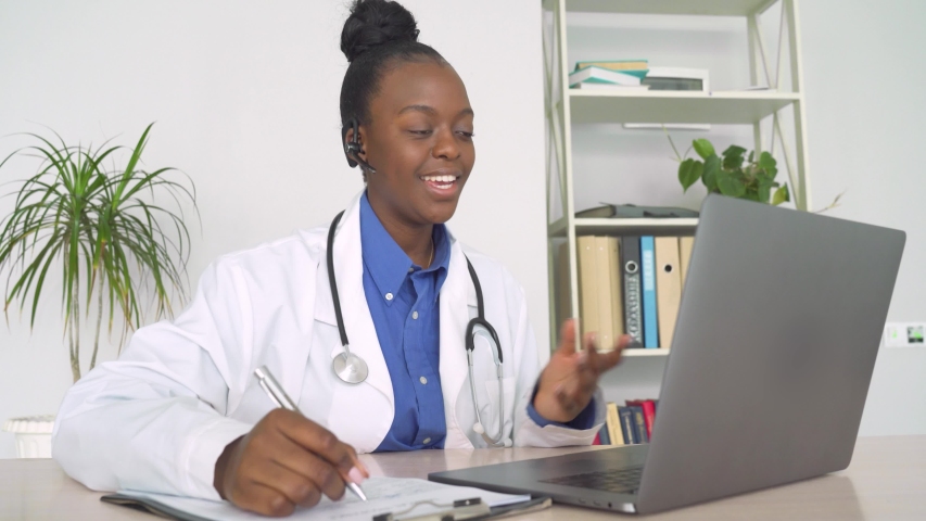 African female doctor talk with patient make telemedicine online webcam video call. Black woman therapist videoconferencing on computer in remote telemedicine laptop virtual chat. Telehealth concept | Shutterstock HD Video #1054741853