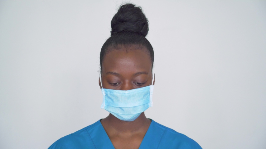 Brave proud female african american scrub nurse wear face mask blue uniform look at camera, tired black woman doctor head shot portrait. Medical staff corona virus covid19 pandemic outbreak protection Royalty-Free Stock Footage #1054741859