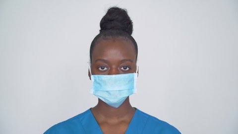 Brave proud female african american scrub nurse wear face mask blue uniform look at camera, tired black woman doctor head shot portrait. Medical staff corona virus covid19 pandemic outbreak protection