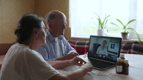 family elderly couple man and woman consult a doctor online about a disease and symptoms during a telemedicine video call, using modern technology while sitting in a computer room