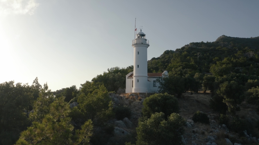 Gelidonya lighthouse on a background of mountains. Beautiful ladscape with green trees. Drone footage 4K