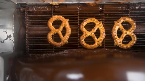 beautiful Top view footage of pretzels going through a chocolate enrober Can be used for many projects and background!