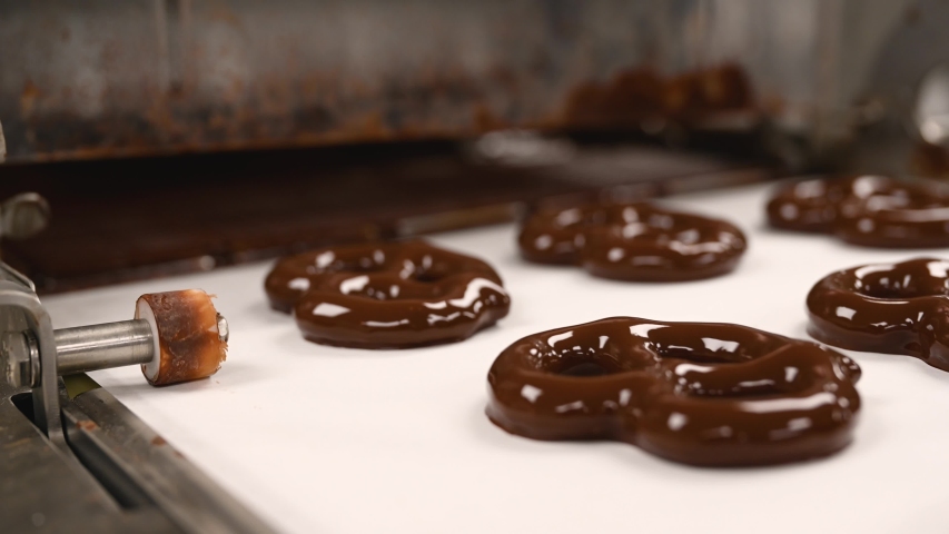 Close up of Chocolate covered pretzels coming out from the chocolate enrober