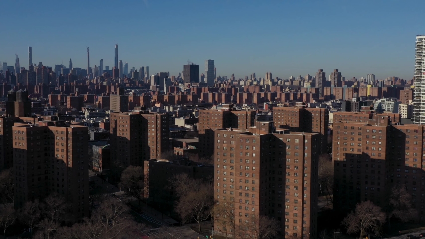 aerial flyover of Harlem NYC housing project in the early morning. Midtown in the distance. Royalty-Free Stock Footage #1054762649