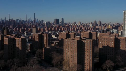 aerial flyover of Harlem NYC housing project in the early morning. Midtown in the distance.