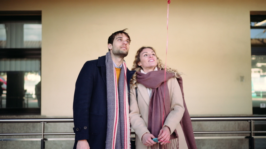 MS Couple standing with red balloon at railroad station / Florence, Italy, People, Transportation