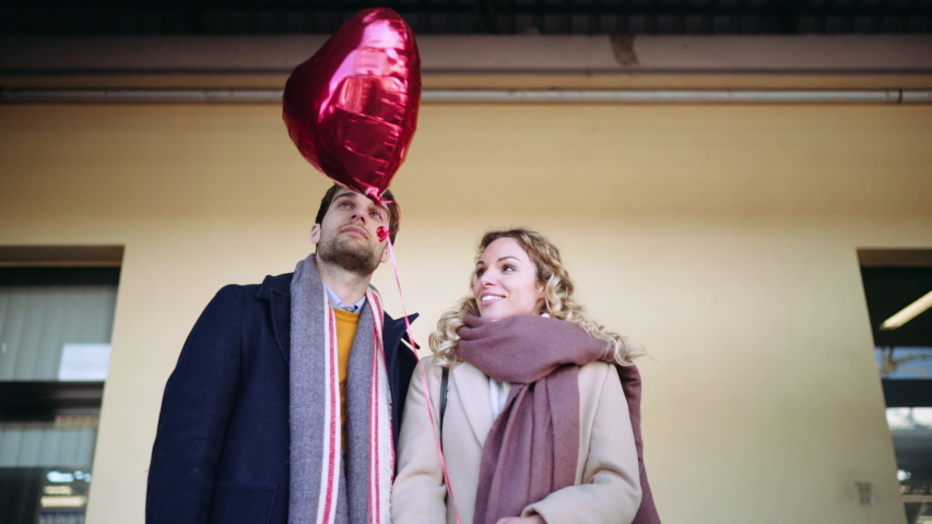 MS Couple standing with red balloon at railroad station / Florence, Italy, People, Transportation