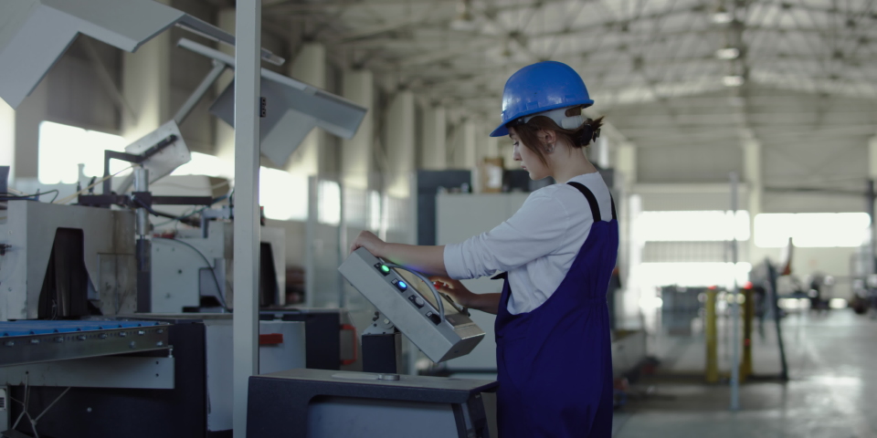 A young lady works in huge hangar