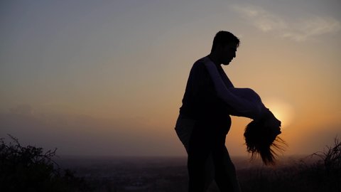 Young dancers couple dancing passionate Latin American dance bachata outdoors in nature at sunset