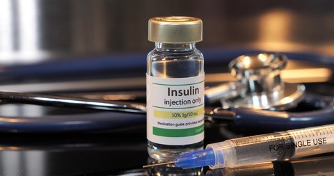 Vial of insulin injection with syringe and stethoscope