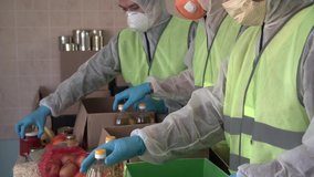Food For The Poor, Feeding the Hungry, Charity organization. Food donation during Coronavirus COVID-19. Hispanic volunteers, social worker in protective suits gloves and masks collect a grocery boxes - Powered by Shutterstock - Get 15% off with code: PIKWIZARD15