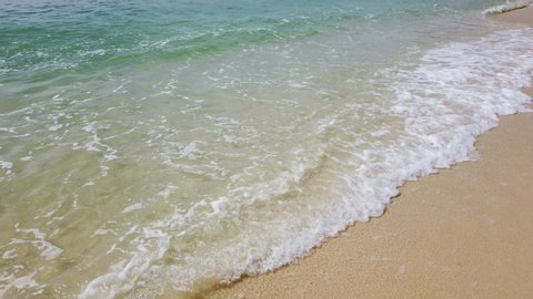 Closeup view of soft sea waves rolling to the sandy tropical beach