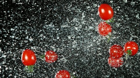 Super slow motion of cherry tomatoes flying up in the air with water splashes. Filmed on high speed cinema camera, 1000 fps.