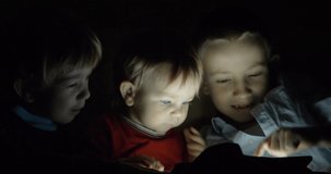 Three brother have fun and watch at tablet screen, night dark, parent hand take gadget