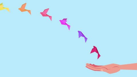Close up of a human hand animation letting go colorful origami birds on blue background. Shot in 4k resolution