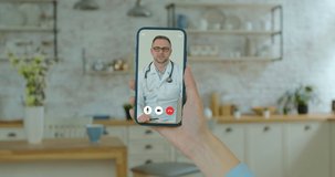 Girl using online chat to talk with professional therapist and checks possible symptoms during. Woman using medical app on smartphone consulting with doctor via video conference.