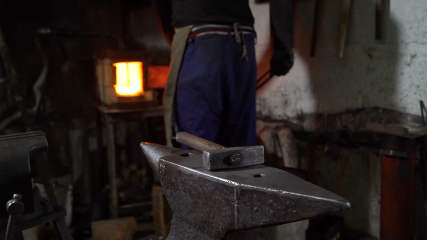 Blacksmith Forging Heated Blade of Knife on the Anvil in Smithy. Man Working with a Hot Metal in a Workshop