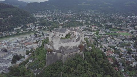 Aerial view of Salzburg castle Aerial view of Salzburg castle on the hill, mountain. Drone flies around Hohensalzburg Fortress Panoramic view of city and salzach river from drone. Historic landmarks
