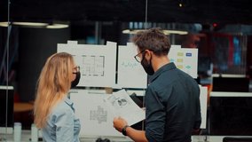 Two Colleagues In Face Mask Office On Covid19 Coronavirus Pandemic Quarantine Lockdown.Coworker Working Together In Lockdown Avoid Self Distance.Employee In Face Mask Cooperating Together On Workplace - Powered by Shutterstock - Get 15% off with code: PIKWIZARD15