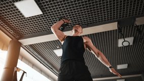 Ligting dumbbell. Young sportive strong man in black wear have workout day in gym. - Powered by Shutterstock - Get 15% off with code: PIKWIZARD15