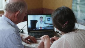 64 modern medicine, an elderly man and an old woman consults a doctor online using a video call on a laptop during a pandemic in isolation