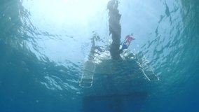 diver jumping in the water from boat underwater diving scenery slow motion ocean scenery sun beams and rays